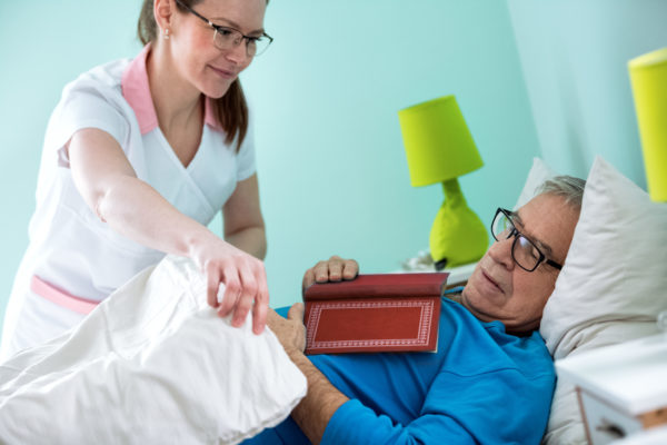 A in-home activities of daily living care giver helping a Tempe, AZ man to bed